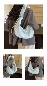 Detail of light blue hobo bag with adjustable ruched shoulder strap and silver buckle