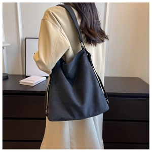 Detailed view of a black oversized minimalist tote bag with matte texture and wide strap