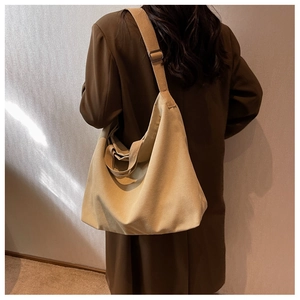 Vue arrière d'un grand sac cabas en toile kaki avec bandoulière réglable sur l'épaule