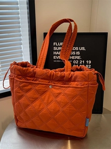 Sac cabas orange matelassé avec surpiqûres en losanges et fermeture à cordon en studio doux