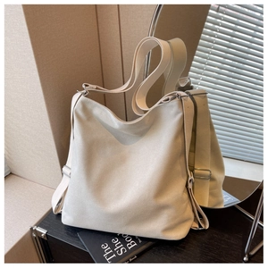 Detail of cream canvas bag showing adjustable wide strap and silver metal hardware