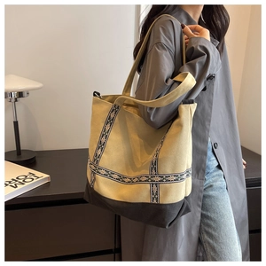 Detail of the khaki canvas tote bag with ethnic woven strap and durable black base
