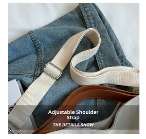 Detail of adjustable off-white canvas strap with silver metal buckle on shoulder bag