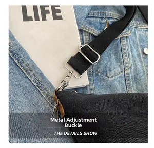 Close-up of adjustable metal buckle and leather joint on a black canvas crossbody bag strap