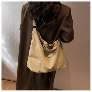 Vue détaillée d'un sac cabas en toile kaki porté par un mannequin pour un look décontracté