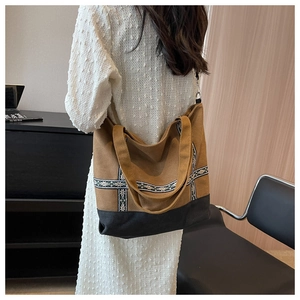 Detail of canvas tote bag featuring ethnic embroidery and brown-black patchwork design