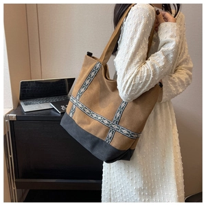 Close-up of large canvas tote bag with brown finish and floral geometric strap details