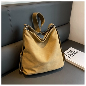 Close-up of mustard yellow canvas tote bag with wide strap and silver metal hardware