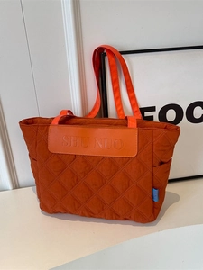 Quilted large capacity orange tote bag with diamond stitching and shoulder straps