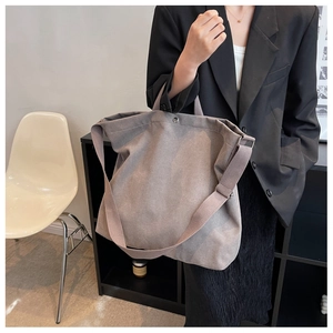 Vue détaillée du grand sac cabas en toile avec bandoulière réglable et bouton pression