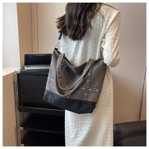 Detail of grey canvas tote bag with ethnic floral embroidery and black contrast base