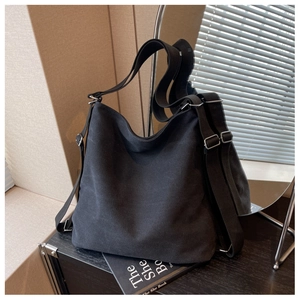 Close-up of black canvas texture and adjustable silver metal buckle on versatile backpack