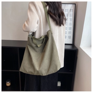 Détail d'un grand sac cabas en toile vert armée avec bandoulière large vue de dos