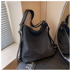 Detail of adjustable strap and silver buckle on a black canvas hobo shoulder bag