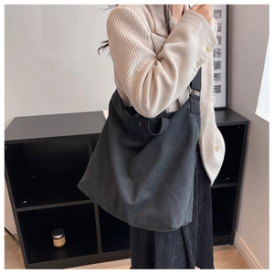 Vue détaillée du sac cabas en toile noire porté par un mannequin en tenue décontractée