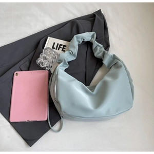 Detail shot of light blue crescent bag with soft ruched handle and metal zipper