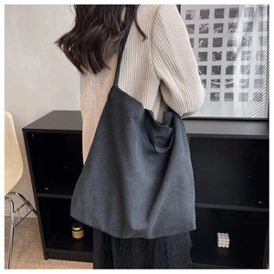 Détail du grand sac cabas en toile noire avec bandoulière réglable et poignées robustes