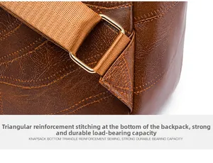 Close-up of reinforced triangular stitching and gold metal buckle on a brown leather backpack