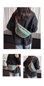 Detail of dark green canvas crossbody bag with orange adjustable strap and round logo