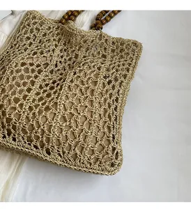 Close-up of woven hollow tote bag featuring dark brown wooden bead circular handles