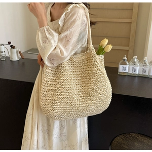 Vue détaillée du grand sac cabas en paille avec texture tissée fine et bandoulière tissée
