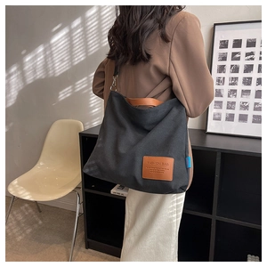 Detail of black canvas tote bag with brown leather patch and stylish striped shadow light