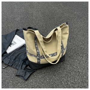 Detail of vintage canvas tote featuring ethnic floral embroidery and reinforced black base