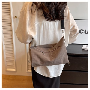 Rear view of deep brown canvas crossbody bag with adjustable black strap and zip pocket