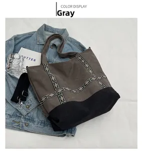 Detail of grey canvas tote bag featuring ethnic embroidery and detachable wide strap