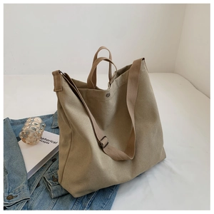 Vue détaillée d'un sac cabas en toile kaki avec bandoulière réglable dans un décor décontracté