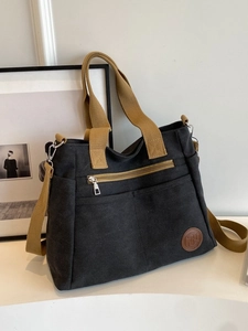 Grand sac cabas en toile noire avec bandoulières kaki et poches frontales pratiques