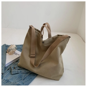 Détail du sac fourre-tout en toile kaki montrant le bouton pression et la bandoulière