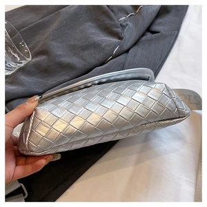 Dettaglio della borsa a tracolla intrecciata argento con texture e cinturino grigio