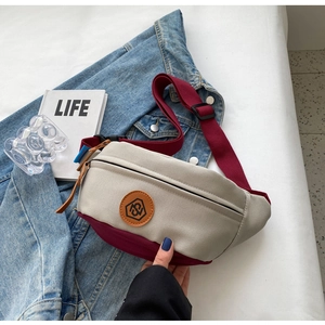 Detailed shot of canvas crossbody bag featuring contrast trim and round logo patch