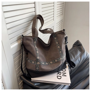 Detail of vintage tote bag featuring ethnic embroidery straps and brown matte fabric