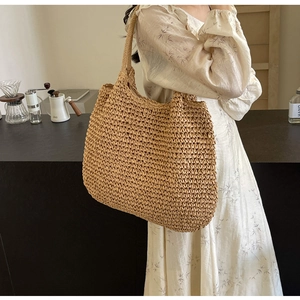 Detail of hand-woven straw tote bag showing natural fiber texture and durable shoulder strap