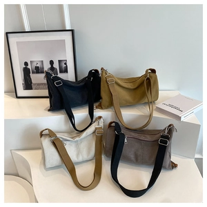 Group display of minimalist canvas shoulder bags in four colors on geometric stands