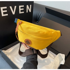 Bright yellow canvas waist bag with adjustable brown strap shown in a black gift box