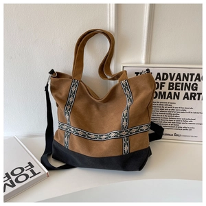 Brown canvas tote bag with ethnic jacquard straps and black reinforced base detail