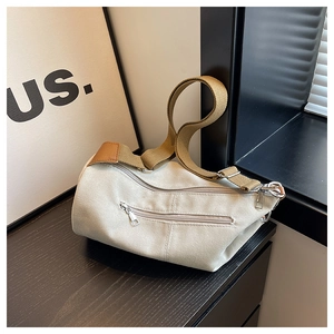 Detail view of the canvas bag showing thick fabric texture and wide woven shoulder strap