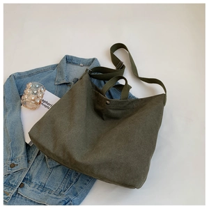 Détail du cabas en toile vert olive avec bouton pression en métal et double bandoulière
