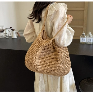 Close-up of a woven tote bag with reinforced handles and detailed texture on a wooden table