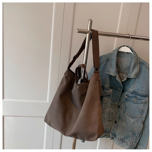 Détail d'un grand sac cabas en toile marron foncé avec bandoulière et bouton pression
