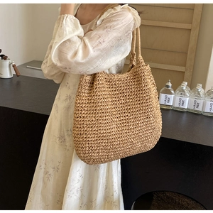 Dettaglio della borsa tote in paglia intrecciata a mano con manici per vacanze estive