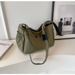 Vue détaillée du sac fourre-tout en nylon olive avec plusieurs poches et bandoulière