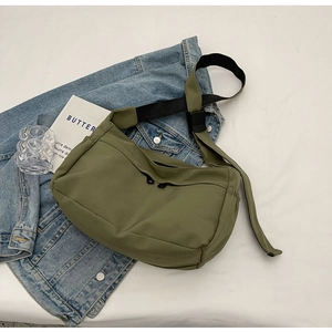Détail du sac bandoulière en nylon vert olive avec deux zips frontaux et bandoulière noire