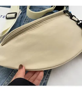 Detailed view of the soft beige canvas crescent bag fabric and black zipper closure