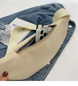 Detailed view of spacious beige crossbody chest bag holding a smartphone inside