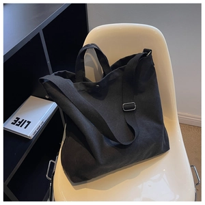Détail du grand sac cabas en toile noire avec bandoulière réglable et grand format