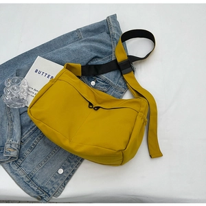 Détail du sac bandoulière en nylon jaune avec double zip et sangle noire réglable